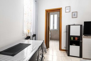 Une chambre comprenant un lit, un bureau, une chaise, une armoire et un téléviseur.