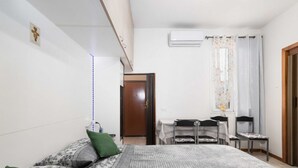 A bedroom with a bed, a desk, a chair, and a door. - Guesthost - N&D Studio Modena Center (Modena)