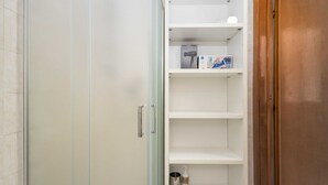 A bathroom with a glass shower enclosure, a white sink, and a shelf with toiletries. - Guesthost - N&D Studio Modena Center (Modena)