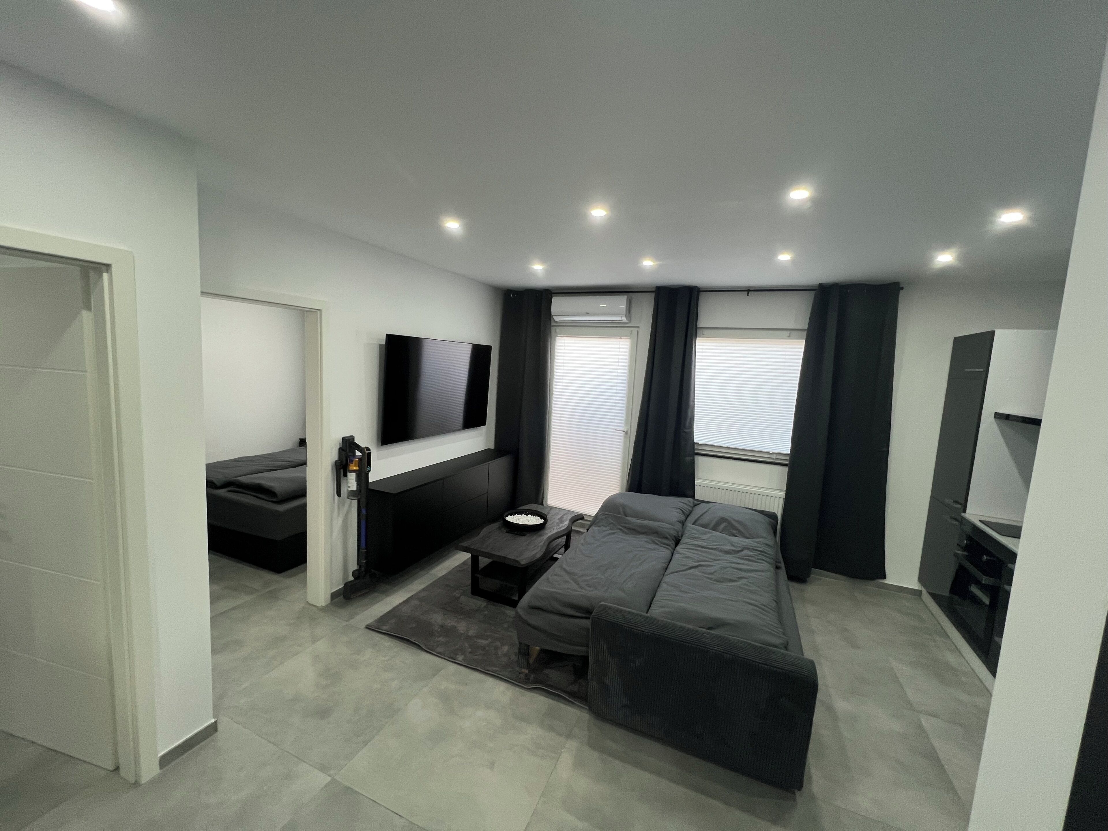 Un soggiorno moderno con un divano, una TV e un tavolino.. Beautiful 3 room apartment near Berlin with private terrace