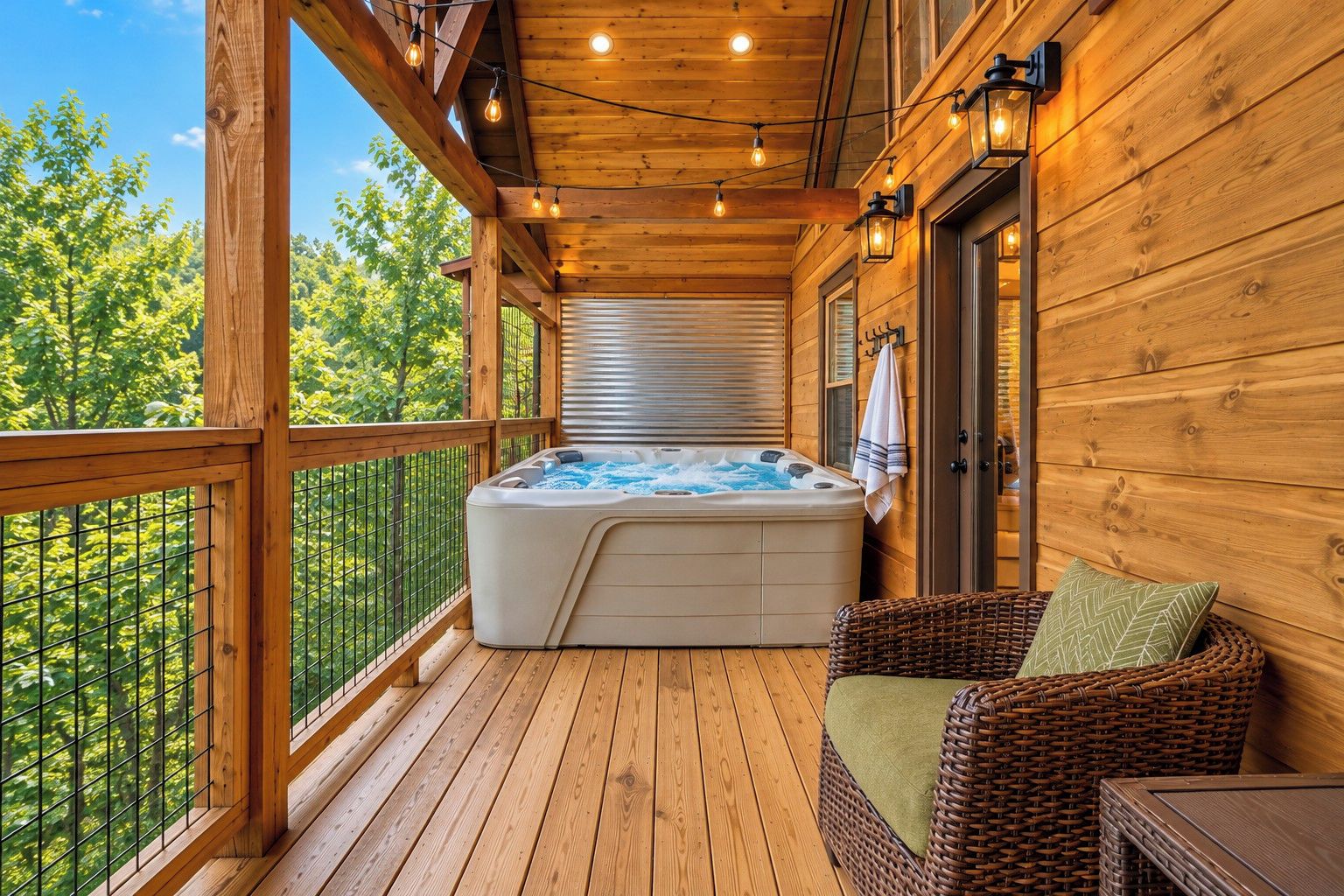 A wooden deck with a hot tub, wicker furniture, and a view of trees.