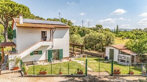 A two-story house with a solar panel roof, a small garden, and a fenced yard. - Podere Pala - Pet Friendly (Grosseto)