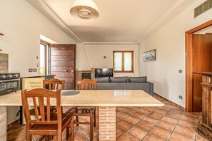 A kitchen with a dining table, chairs, a TV, and a sofa. - Podere Pala - Pet Friendly (Grosseto)