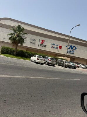 Un edificio con varios letreros de tiendas, incluyendo 'Maxx', 'Fitness First' y 'Cineo'.