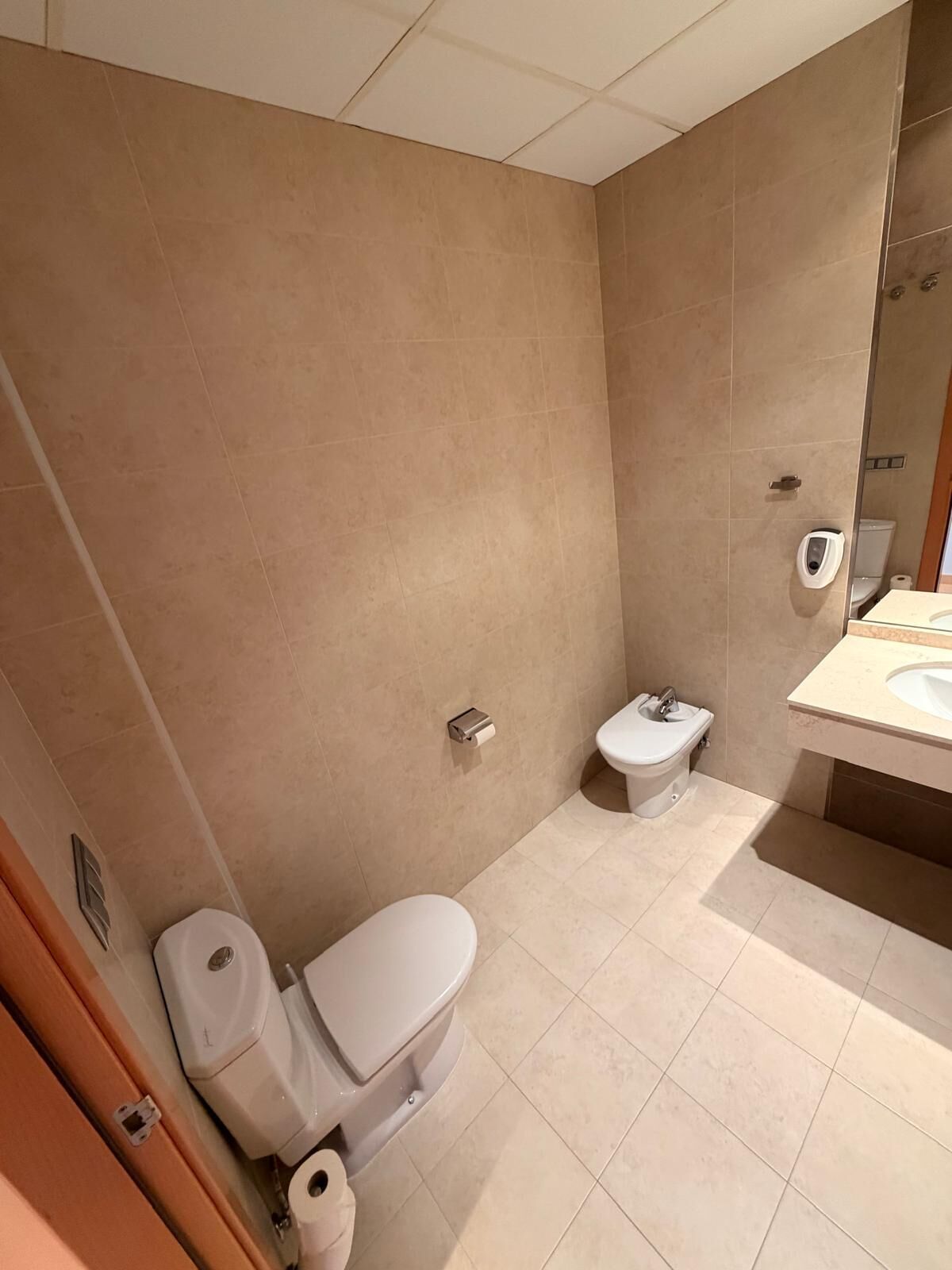 Un baño con inodoro, bidé y lavamanos.