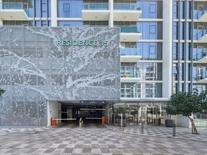 Ein modernes Gebäude mit einer einzigartigen, perforierten Fassade und einem gut sichtbaren Eingang.