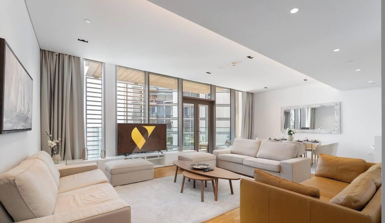 A modern living room with a sofa, coffee table, and a flat-screen TV.