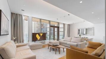 A modern living room with a sofa, coffee table, and a flat-screen TV.
