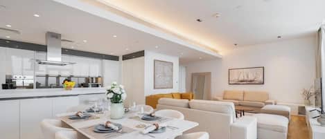 A modern living space with a dining area, kitchen, and seating area.
