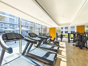 A gym with treadmills, exercise equipment, and large windows. - Vogue, JVC Luma22 West near Circle Mall (Jumeirah Village Circle ( JVC ))