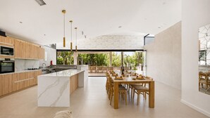 A modern kitchen with a marble island, wooden cabinets, and pendant lighting. - Villa Tropical |Pool|Jacuzzi|Bar|BBQ|AC|16 Pax (VALENCIA)