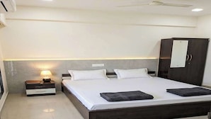 Een moderne slaapkamer met een groot bed, nachtkastjes, een kledingkast en een plafondventilator.