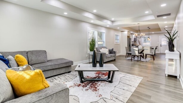 A modern living room with a grey sofa, a coffee table, and a dining area with chairs and a table. - Plush 3b/2b house on ATL lovely WestEnd. Next to 2 Marta St. 10 min from M Benz. (Atlanta)