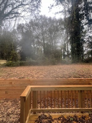 Une terrasse en bois offrant une vue sur une zone boisée.
