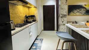 Una cocina moderna con una isla central, una zona de comedor con barra y una puerta de madera oscura que da a otra habitación.