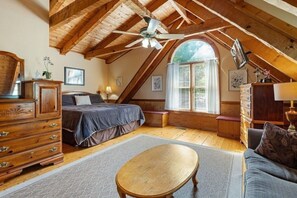 Ein gemütliches Schlafzimmer im Dachgeschoss mit Bett, Schminktisch und Holztisch.