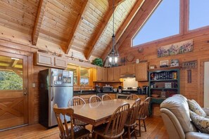 Ein Holzblockhaus-Interieur mit einer Küche, einem Essbereich und einem gemütlichen Wohnraum.