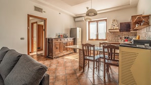 A kitchen with a dining area, a sofa, and a TV. - Podere Pala - Pet Friendly (Toscana)