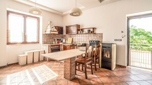 A kitchen with a dining table, chairs, a stove, and a refrigerator. - Podere Pala - Pet Friendly (Toscana)