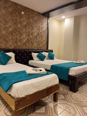 A hotel room with two beds, a wooden headboard, patterned wallpaper, and a tiled floor. - Sree Simran Grand (Hyderabad)