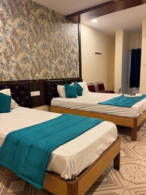 A hotel room with two beds, a patterned wallpaper, and a tiled floor. - Sree Simran Grand (Hyderabad)