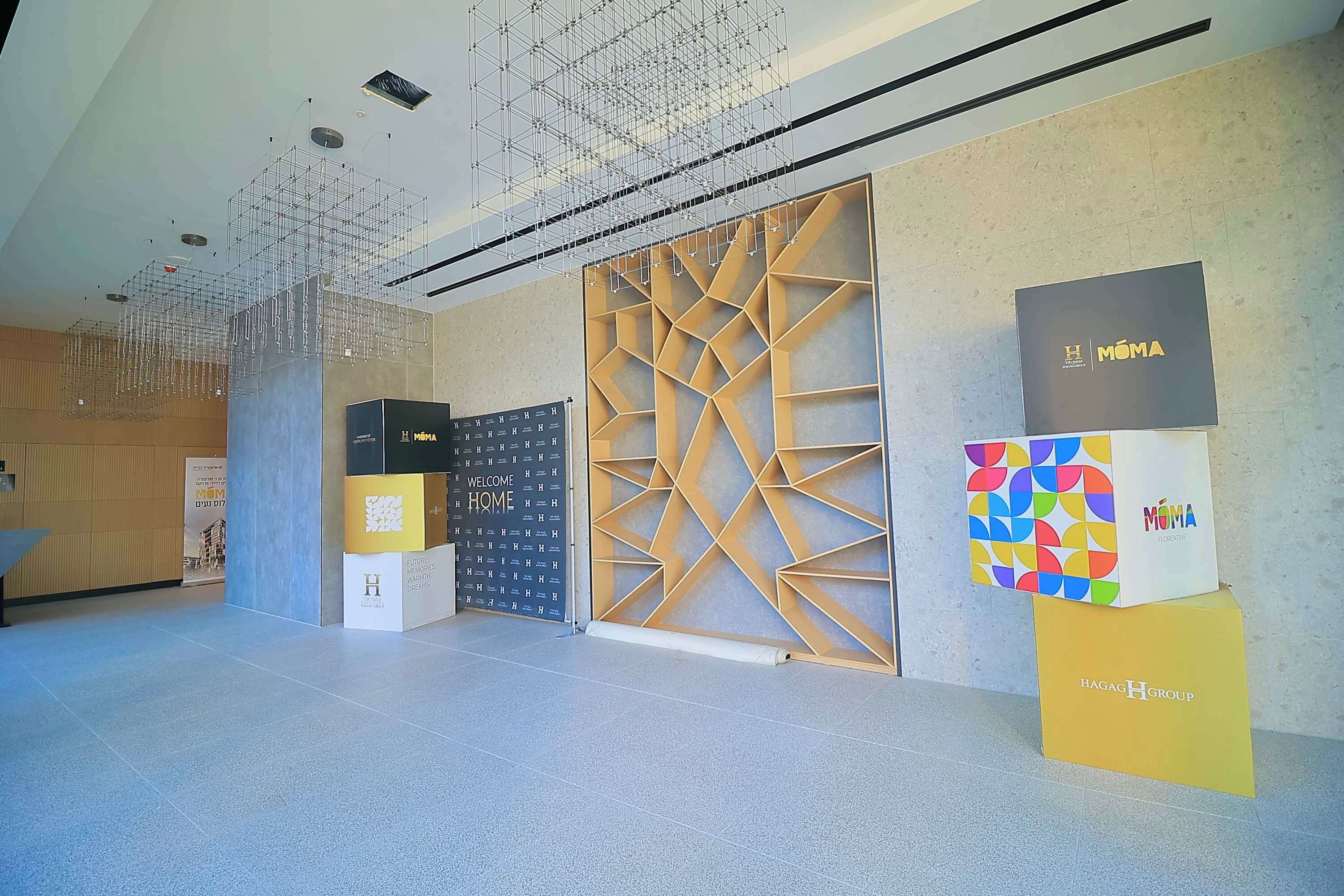 A modern interior with a geometric wall design, a suspended ceiling, and branded display boxes.