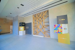 Ein modernes Interieur mit geometrischem Wanddesign, abgehängter Decke und markenspezifischen Ausstellungsboxen.