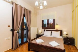 Ein Schlafzimmer mit einem Bett, zwei Nachttischen, einem Fenster, einer Heizung und einer Deckenleuchte.