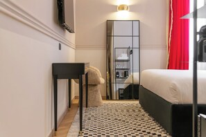 A bedroom with a bed, a mirror, a desk, and a wardrobe. - The Couper Duomo (Milan)