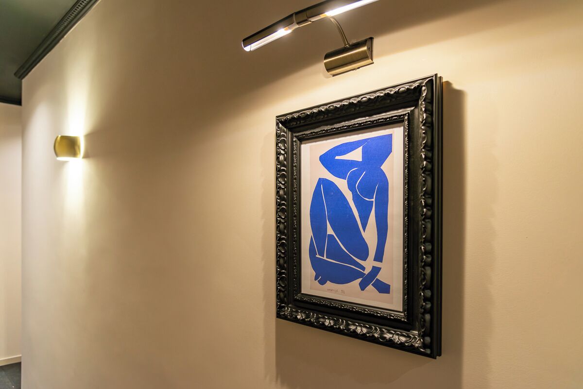 Une œuvre d’art abstraite encadrée, accrochée au mur d’un couloir.