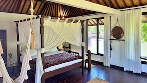 A four-poster bed with a canopy, a hanging hammock, and a large window with curtains. - Unique 1BR Villa Ubud Center (Ubud)