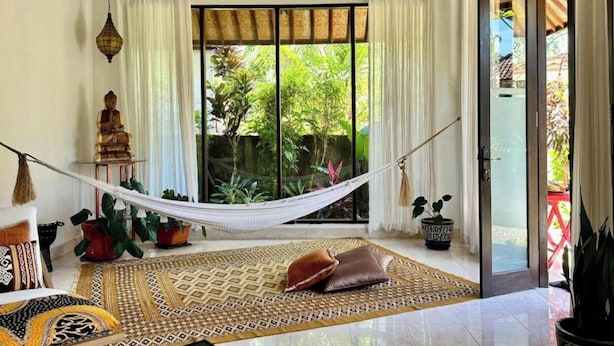 A room with a hammock, a Buddha statue, and potted plants. - Unique 1BR Villa Ubud Center (Ubud)