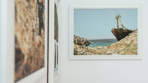 Fotografía enmarco de un naufragio en una costa rocosa bajo un cielo despejado.