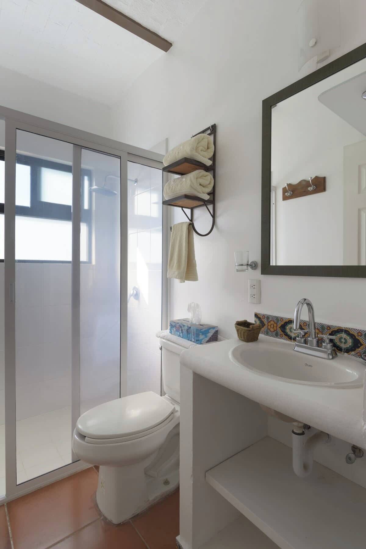 Une salle de bain équipée de toilettes, d’un lavabo et d’un porte-serviettes.
