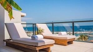 Two sun loungers with towels, a potted plant, and a view of the marina. - Exceptional penthouse - panoramic view (Cannes)