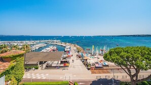 A marina with boats, a paved walkway, and a tree. - Exceptional penthouse - panoramic view (Cannes)