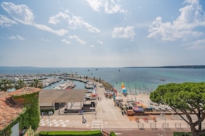 Ein Yachthafen mit Booten, ein Strandabschnitt und ein Gebäude mit Ziegeldach.