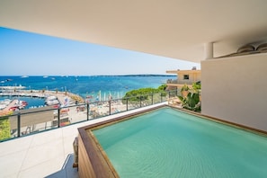 Ein Balkon mit Blick auf einen Yachthafen und ein Schwimmbad.