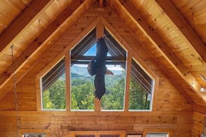 Ein Holzinnenraum mit hoher Decke und einem großen Fenster.