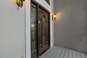 Eine Holztür mit Glasfeldern und einer an der Wand befestigten Leuchte.