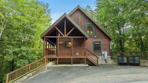 A log cabin with a porch, a staircase, and a fenced area. - Forget Me Not: Memories You'll Never Forget (Pigeon Forge)