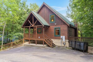 A log cabin with a porch, stairs, and a fenced area. - Forget Me Not: Memories You'll Never Forget (Pigeon Forge)