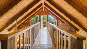 Una habitación en el ático con una escalera de madera que da a un balcón.