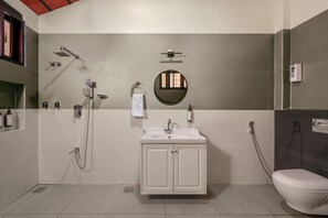 Un bagno con lavandino bianco, WC, doccia e specchio.