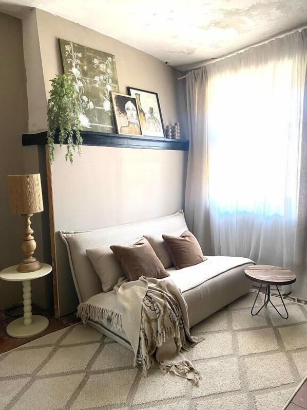 A cozy room with a sofa, a small round table, a lamp, and a plant. - Dreamhome B&B Limoux (Limoux)