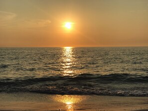 Ein Sonnenuntergang über einem ruhigen Meer mit sanften Wellen.