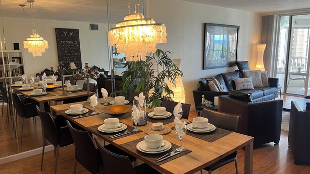A dining area with a long wooden table set for a meal, surrounded by chairs. - Apartment in Paradise! Feb/March 2027 availability! (Naples)