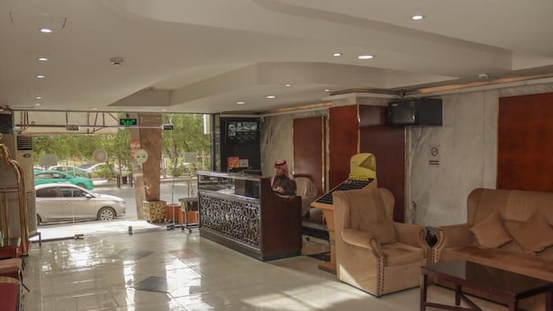 A hotel lobby with a reception desk, seating area, and a view of the street. - Al Orouba Hotel (Riyadh)