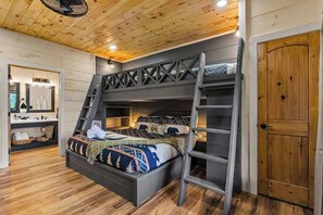 A bunk bed with a ladder, a wooden door, and a mirror in a room with wooden flooring. - Nice Views, Theater, Gameroom, Arcade, Hot Tub (Pigeon Forge)