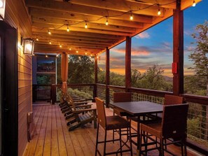 Una terraza de madera con mobiliario exterior y vistas al paisaje.